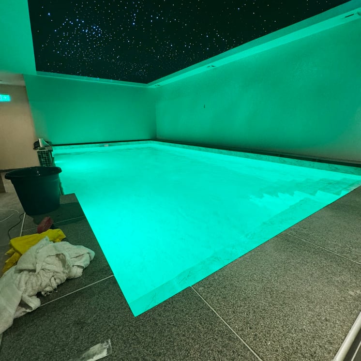 indoor zwembad met groene verlichting en sterrendak