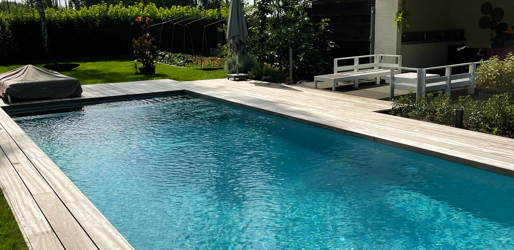 zwembad met houten terras en helder blauw water