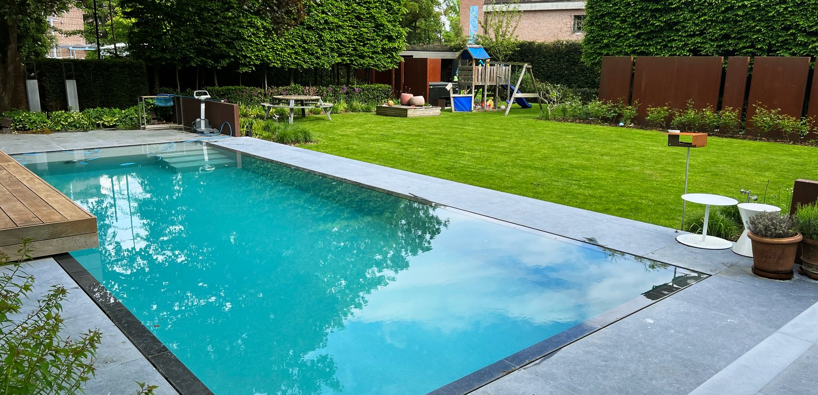 moderne zwembadrenovatie bij speeltuin en groene tuin