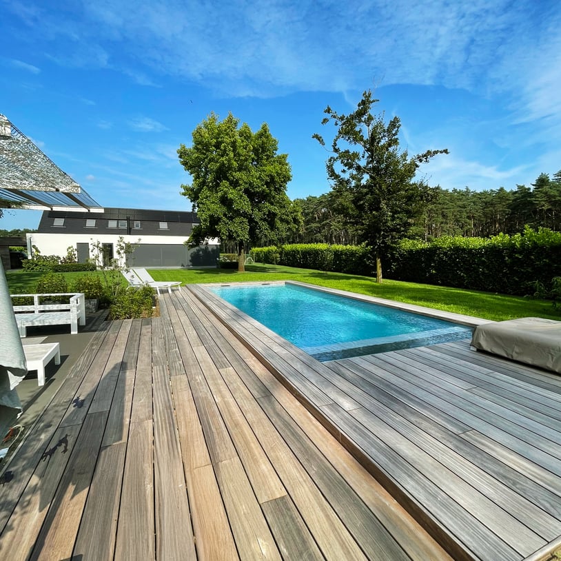 houten terras bij zwembad met blauwe lucht