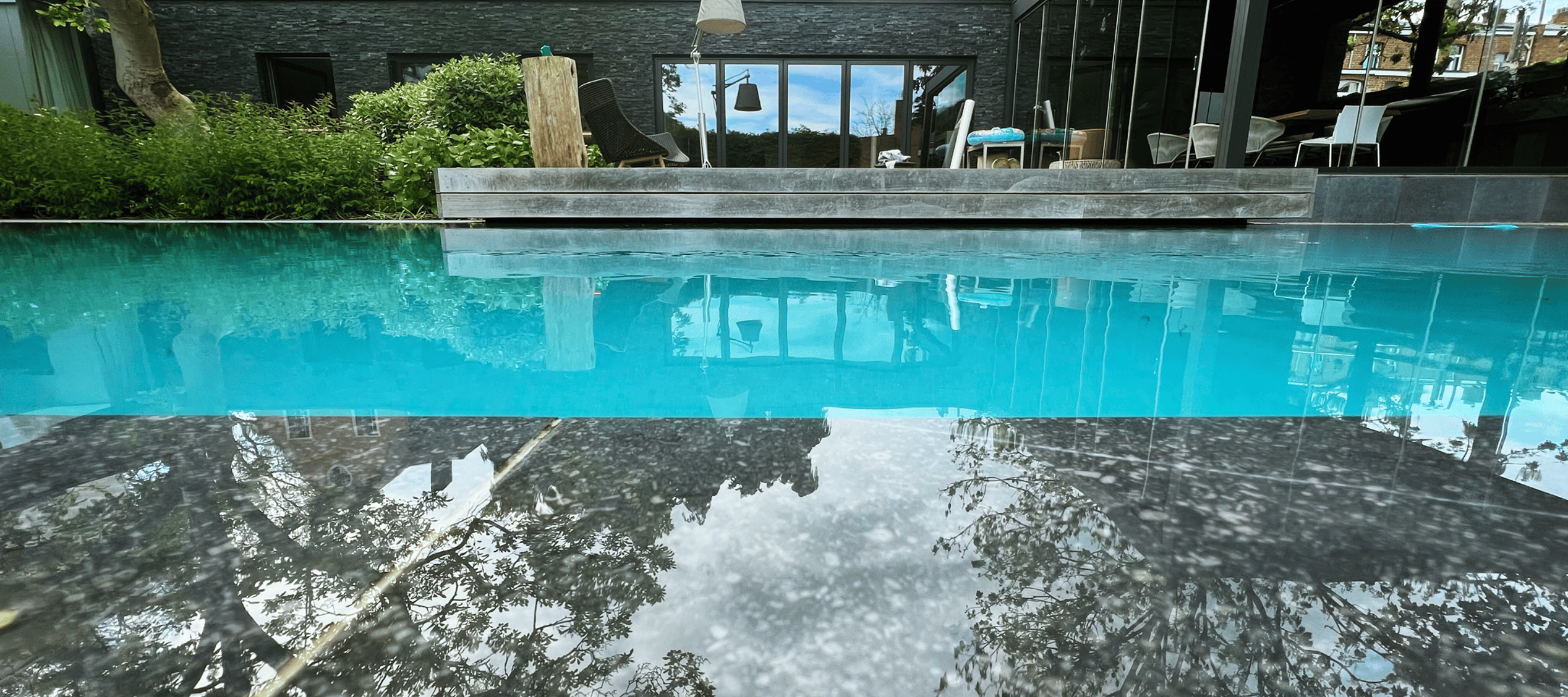 zwembad met moderne woning en waterreflectie