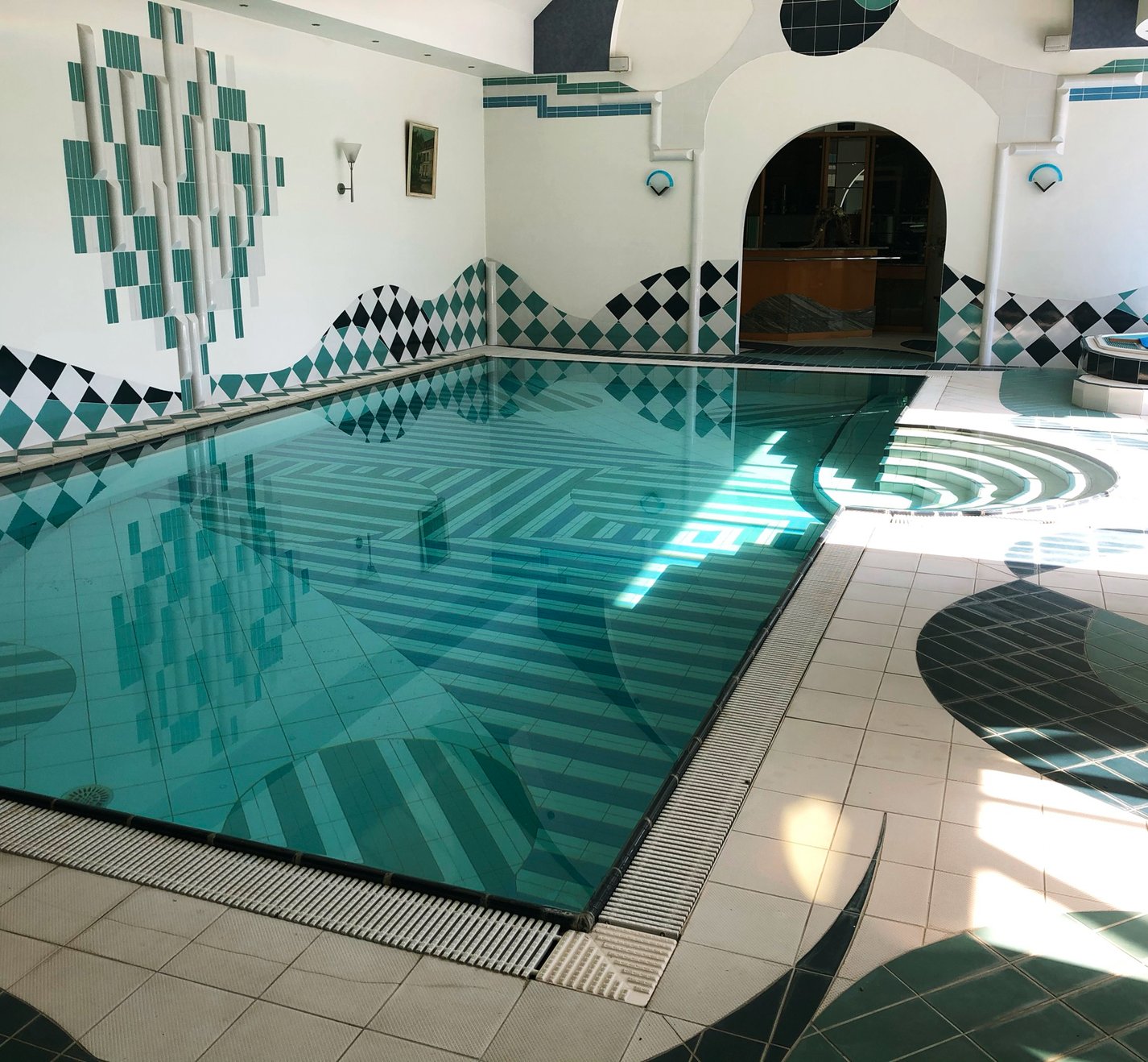 binnenzwembad met patroontegels en jacuzzi